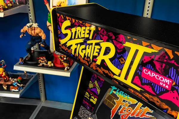 The lit Street Fighter II marquee next to a shelf of fighter figures